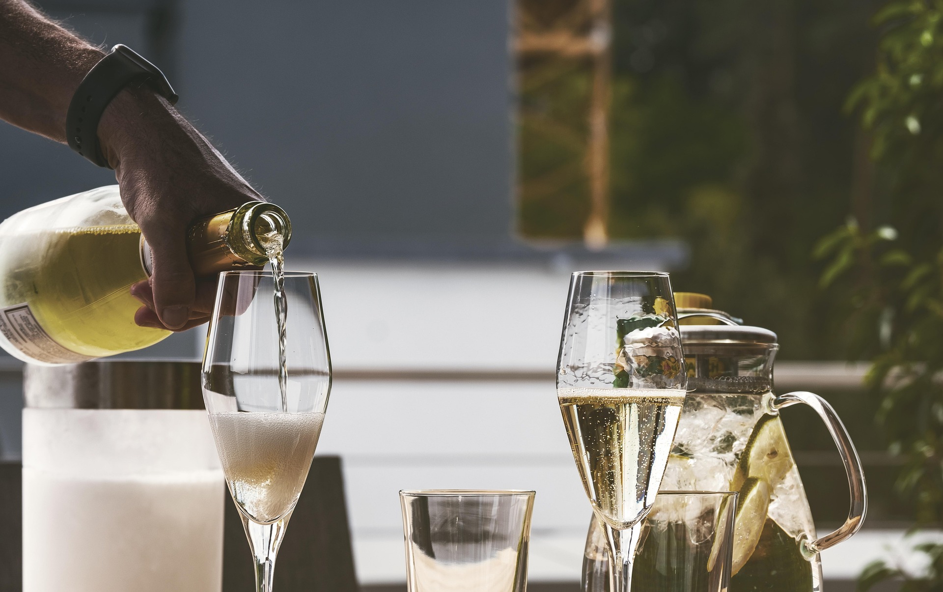A scene of a quiet restaurant with a setting for two. There is wine being poured into wine glasses.